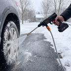 Rinsing road salt off a car wheel with the TorqueWash cordless pressure washer